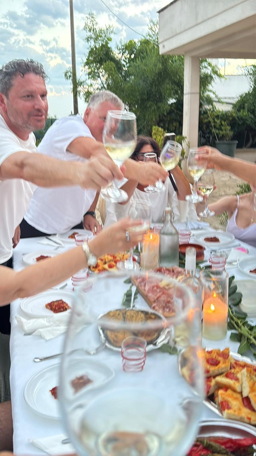 Friends raising their glasses around an outdoor dinner table